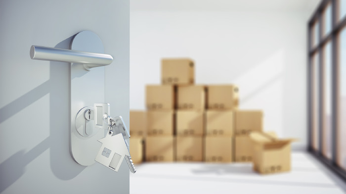 © peterschreiber.media, stock.adobe.com Offene Tür vor heller Wohnung mit Umzugskartons