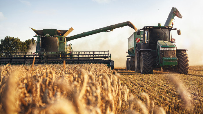 © photoschmidt, stock.adobe.com Mähdrescher und Traktor bei der Ernte auf einem Weizenfeld