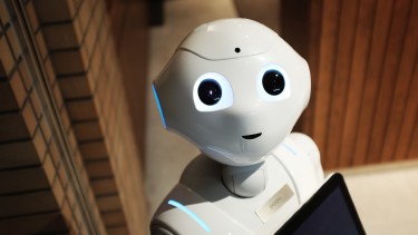 Humanoider Roboter, der ins Bild zu lächeln scheint und freundlich schaut